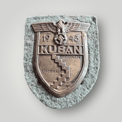 A Heer Kuban Campaign Shield made of bronzed steel features a map of the Kuban region with "KUBA," a Wehrmacht eagle, a wreathed mobile swastika, and the date "1943." It is attached with four prongs to a magnetic backplate, field-grey wool liner.