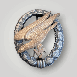 An early Luftwaffe Fallschirmjäger Badge By Assmann & Söhne - Type E, constructed in tombak. The obverse depicts an oval laurel and oak leaf wreath, with a diving eagle clutching a swastika, with nice attractive gilt finish.