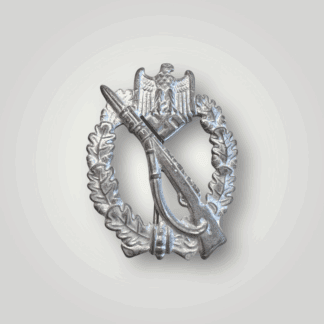 This mid to late war Infantry Assault Badge in Silver by Wiedmann is made of zinc. It features an oak leaf wreath, a national eagle with swastika, and a K98 rifle with bayonet and sling.