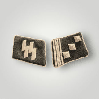 A set of Waffen-SS Haupsturmfuhrer collar boards. The left collar board is hand-embroidered in silver bullion wire with silver twisted braid edging on black doeskin material.