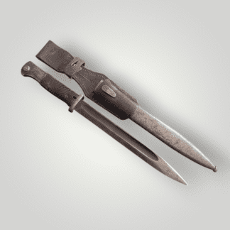 A rare WW2 German Heer K98 Dress Bayonet by JWH 42 with matching numbers, with orginal leather frog and scabbard. The handle has a brown bakelite grip. The ricasso of the blade is stamped “JWH" for Nationale Staatliche Waffenfabrik, Châtellerault, France.