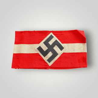 An original Hitler Youth HJ armband, constructed from red cotton with a finely woven white central stripe. The obverse of the armband features a machine-woven swastika diamond securely stitched to the band.