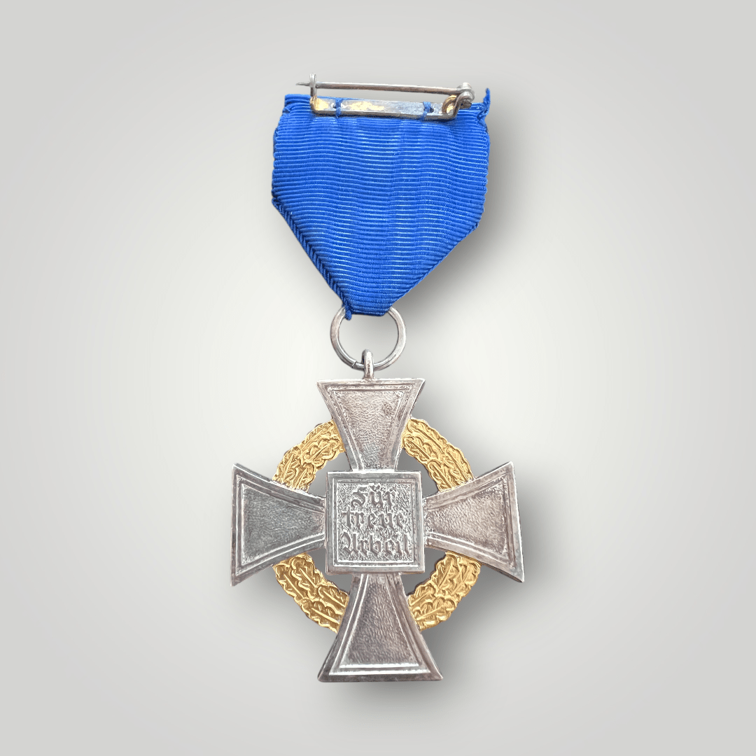 A rare National Faithful Service Medal 50 Years with presentation case, constructed from die-struck nickel silver base with gold-coloured gilt. The medal features a cross pattée with an oak leaf wreath running between the cross’s arms, with a black-enamelled swastika in the centre bearing the number 50 in gold in the top arm.