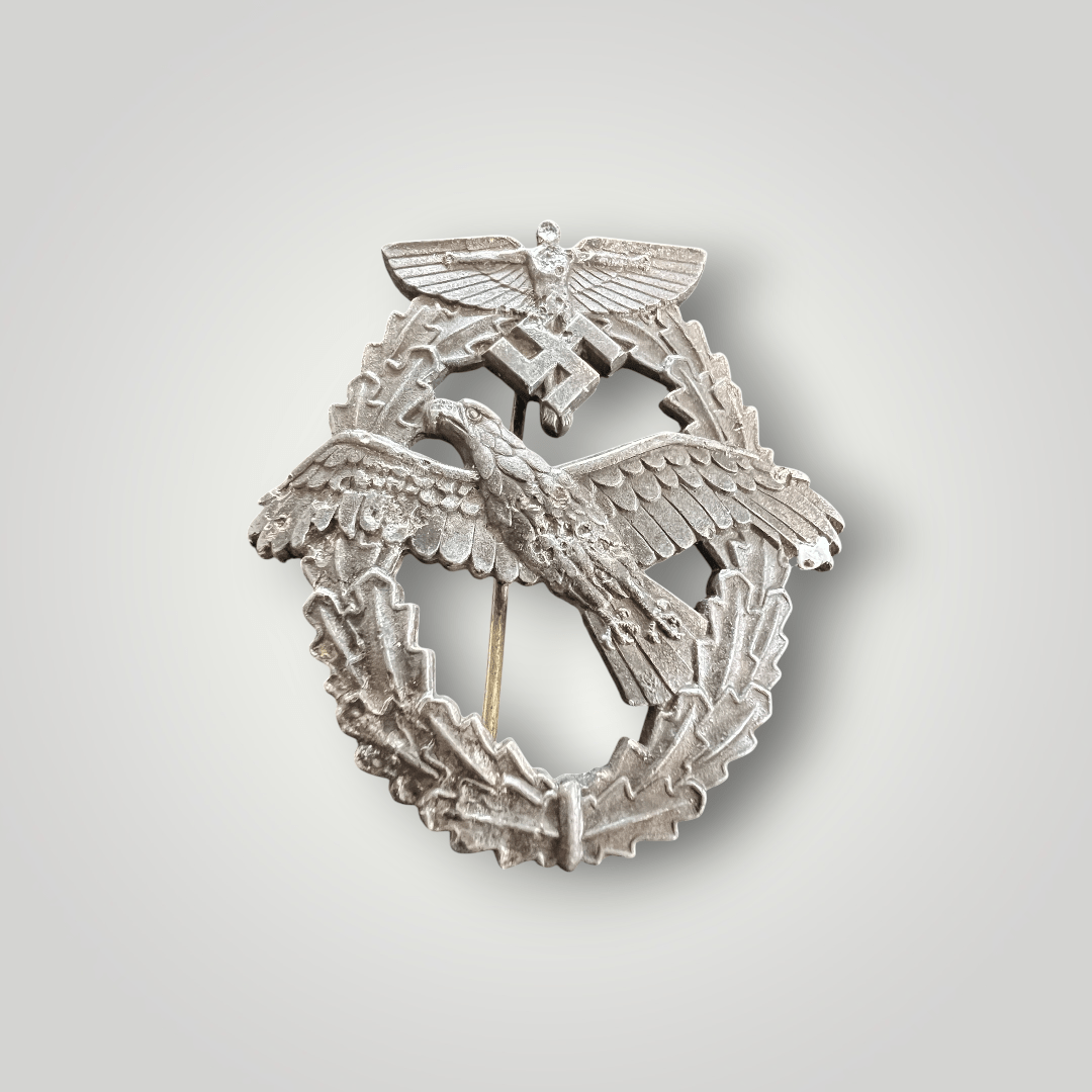 This is rare NSFK Powered Aircraft Pilot Badge 3rd Pattern (National Socialist Flyers Corps), constructed from zinc. The obverse features an oval oak leaf wreath topped by an NSFK insignia depicting Icarus, superimposed with a mobile swastika.