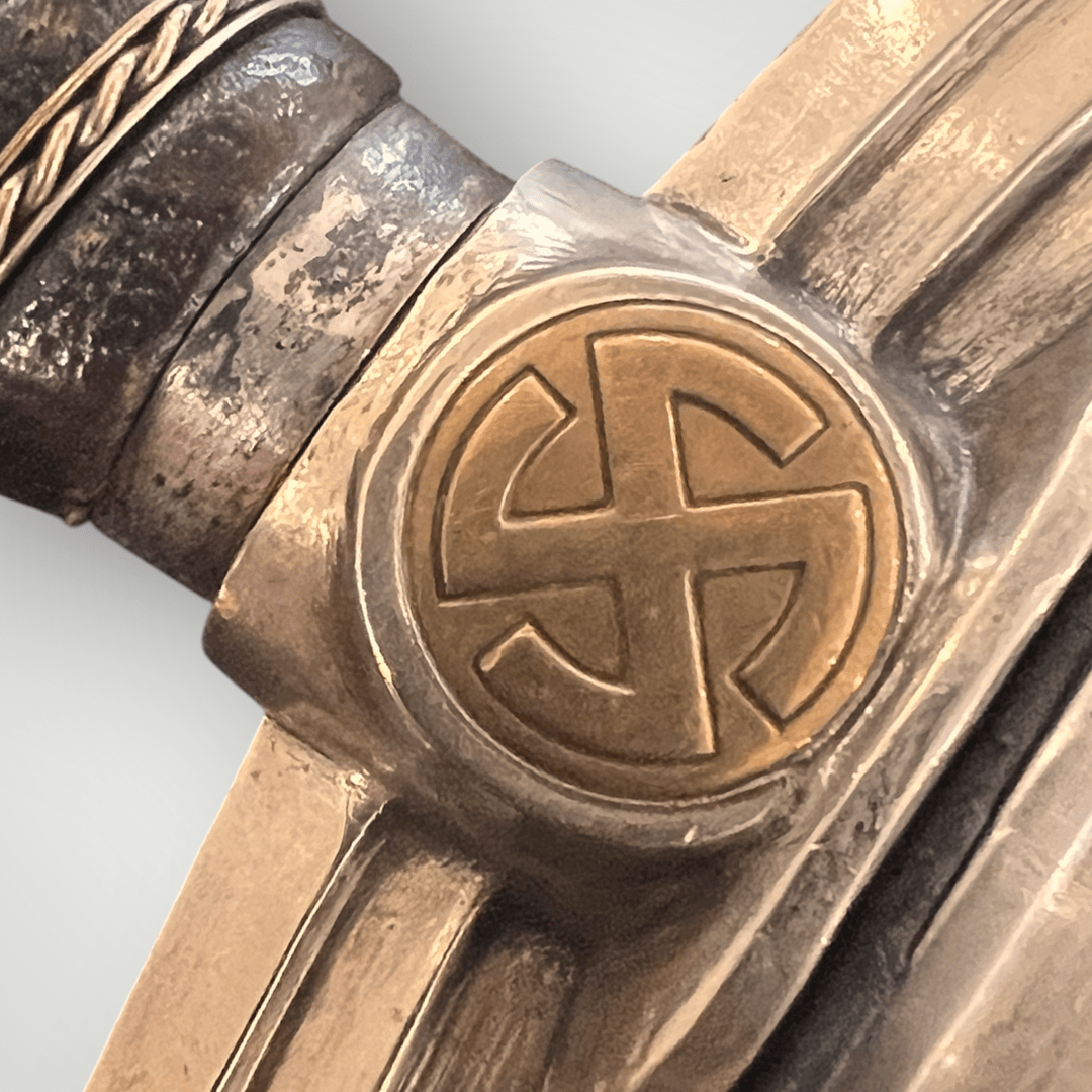 A photo of a Luftwaffe Dress Dagger 1st Model by Hörster Solingen, cross guard with brass sun beam swastika.