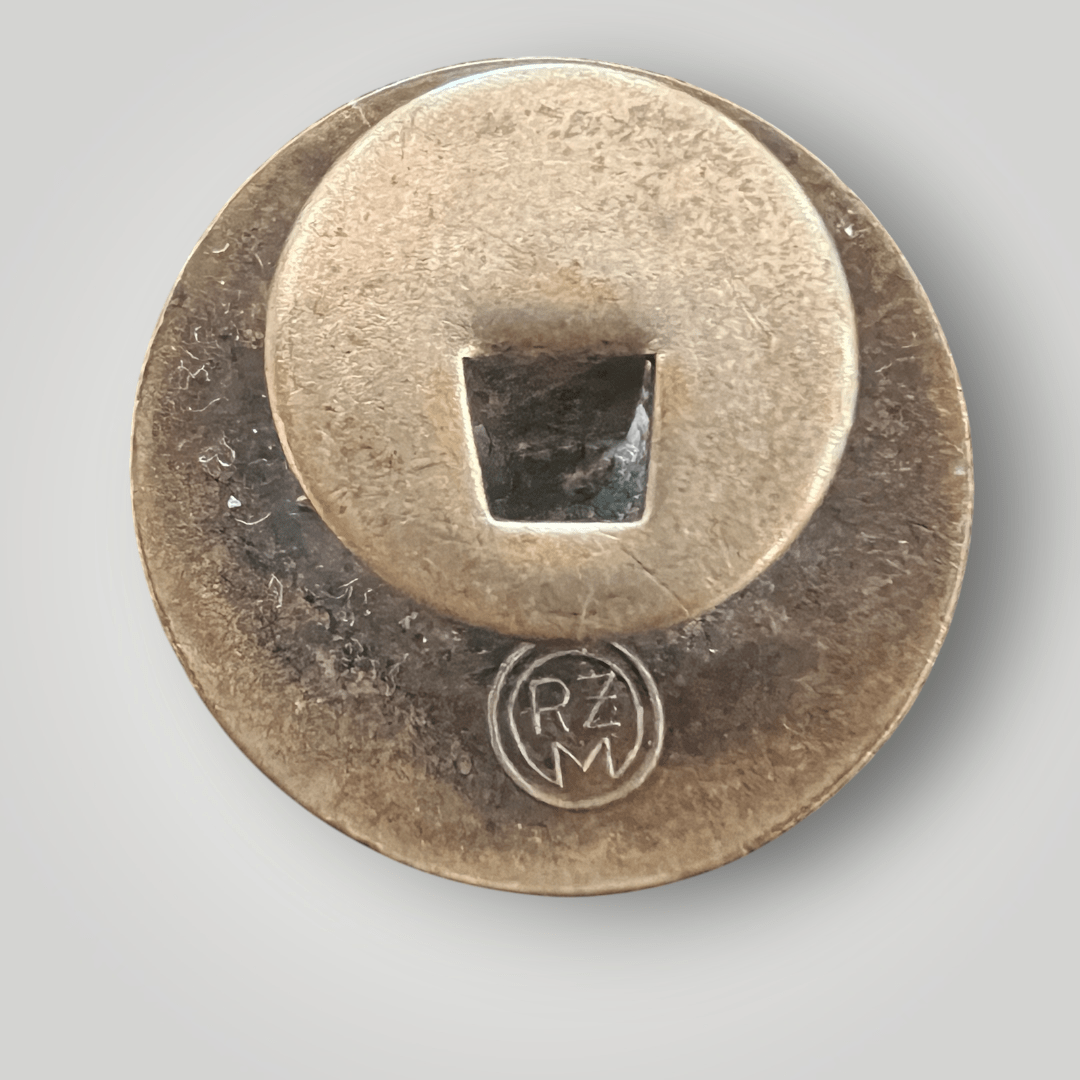 The reverse image of a NSDAP Party Badge button hole by Fritz Zimmermann, constructed in white, red, black, and gold enamel.