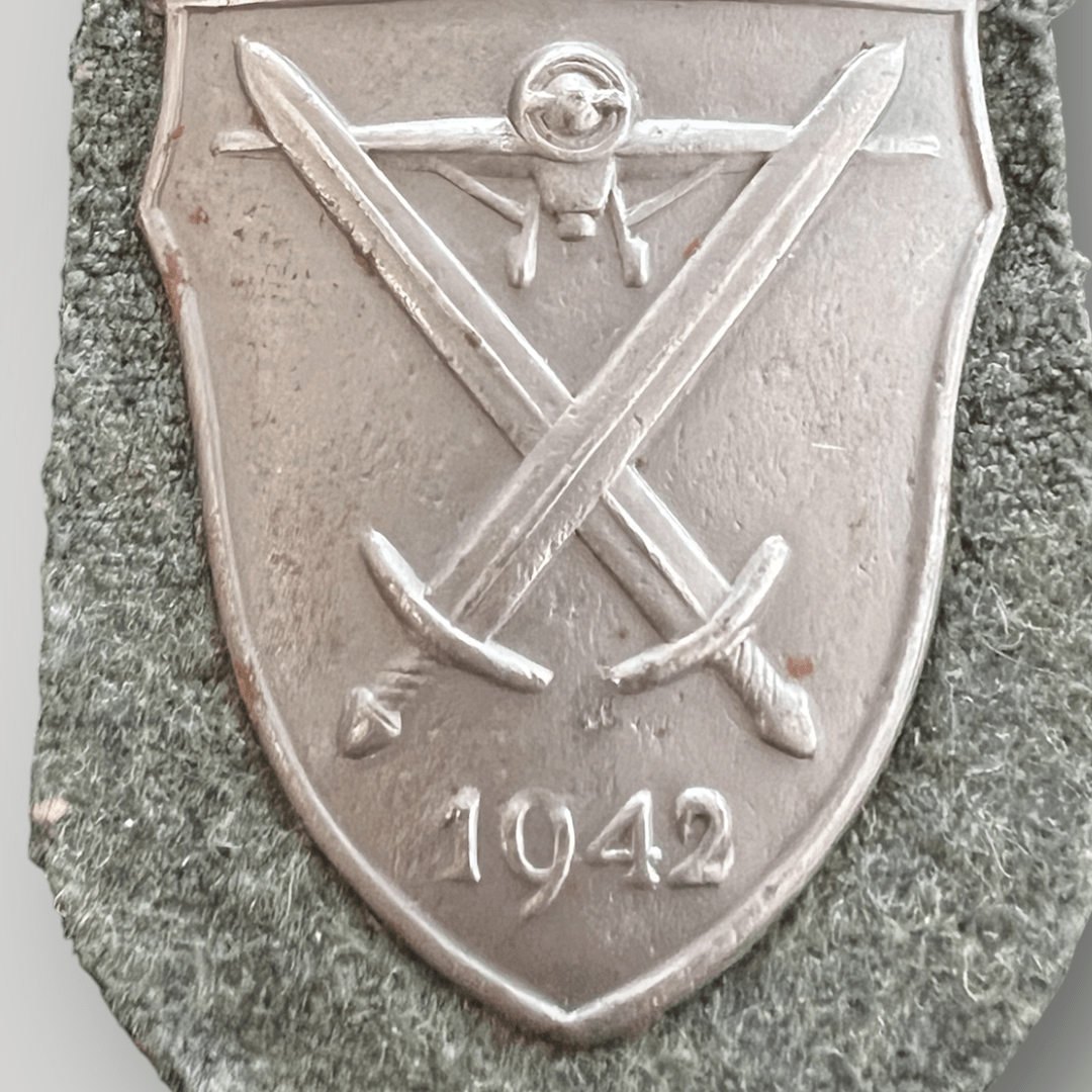 An original Heer Demjansk shield, die-struck with silver wash.