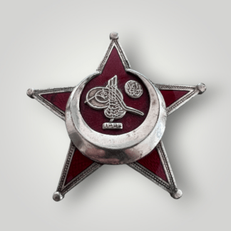 An original Gallipoli Star By B.B & Co, Berlin, constructed in nickel-plated brass. The obverse of the medal depicts a five vaulted star, in red enamel. The tips of the star are capped with a ball finials with a raised silver edge.