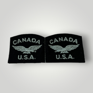 An original set of WW2 RCAF United States Volunteer Shoulder Eagle titles, machine embroiderd with light blue thread on dark blue wollan backing.