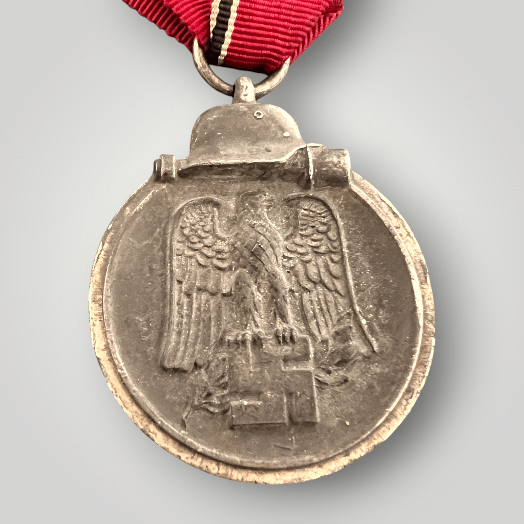 An genuine German WW2 Eastern Front Medal unknown maker, constructed in zinc. The suspension ring unmarked complete with the original ribbon in good condition.
