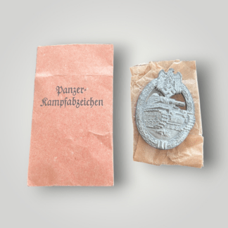 An outstanding original mid to late war Heer Panzer Assault Badge in Silver by  Frank & Reif of Stuttgart, complete with its original presentation packet. The badge is constructed in zinc and retains a bright silver wash with nice patina.