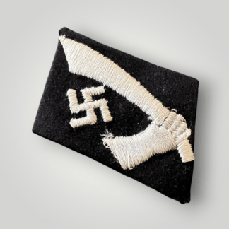 An original 13th Waffen-SS Mountain Division Handschar Collar tab, hand embroidered with silver-grey thread on typical SS black wool. The obverse of the badge depicts a wielding scimitar beside a mobile swastika.