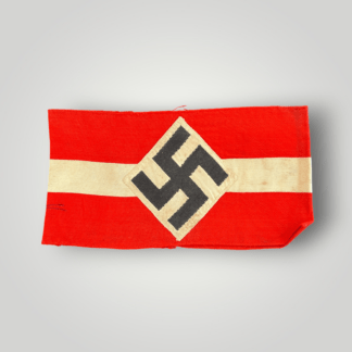 A genuine Hitler Youth cloth armband, constructed in red cotton the exterior bearing a central machine-embroidered white cotton band, overlaid by a white cotton diamond bearing a black mobile swastika.