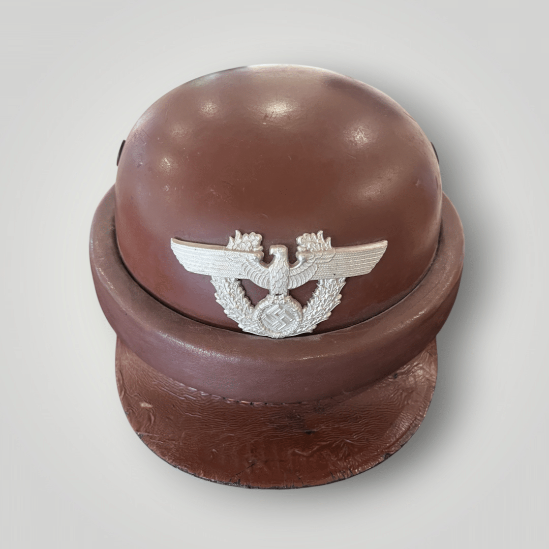 A genuine German WW2 Gendarmerie Police Motorcycle Helmet by Erel, constructed in fibreglass and brown leather. The sides include round ventilation grills with raised protective padding around the edge. The front of the helmet includes aluminium Police eagle.