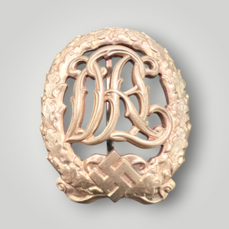 An original German DRL Sports Badge Gold, tombac construction. The obverse consists of "DRL' script superimposed in the centre surrounded by an oak wreath with a swastika and bow below. 