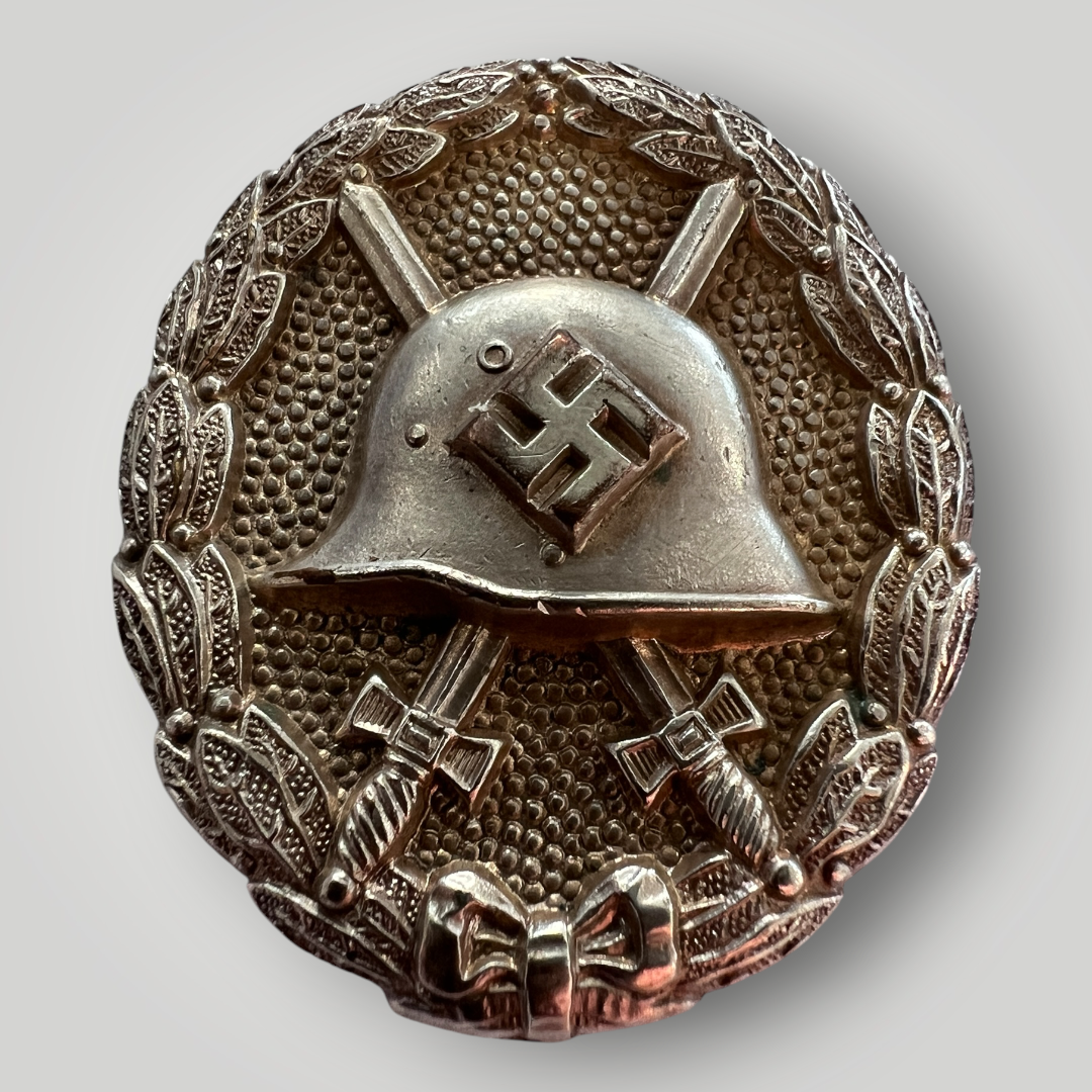An original German WW2 Silver Wound Badge 1st Pattern Legion Condor, die-stamped in tombac with a hollow-back construction and silvered finish. This pattern was awarded to members of the Condor Legion, giving rise to the designation “Condor Wound Badge”.